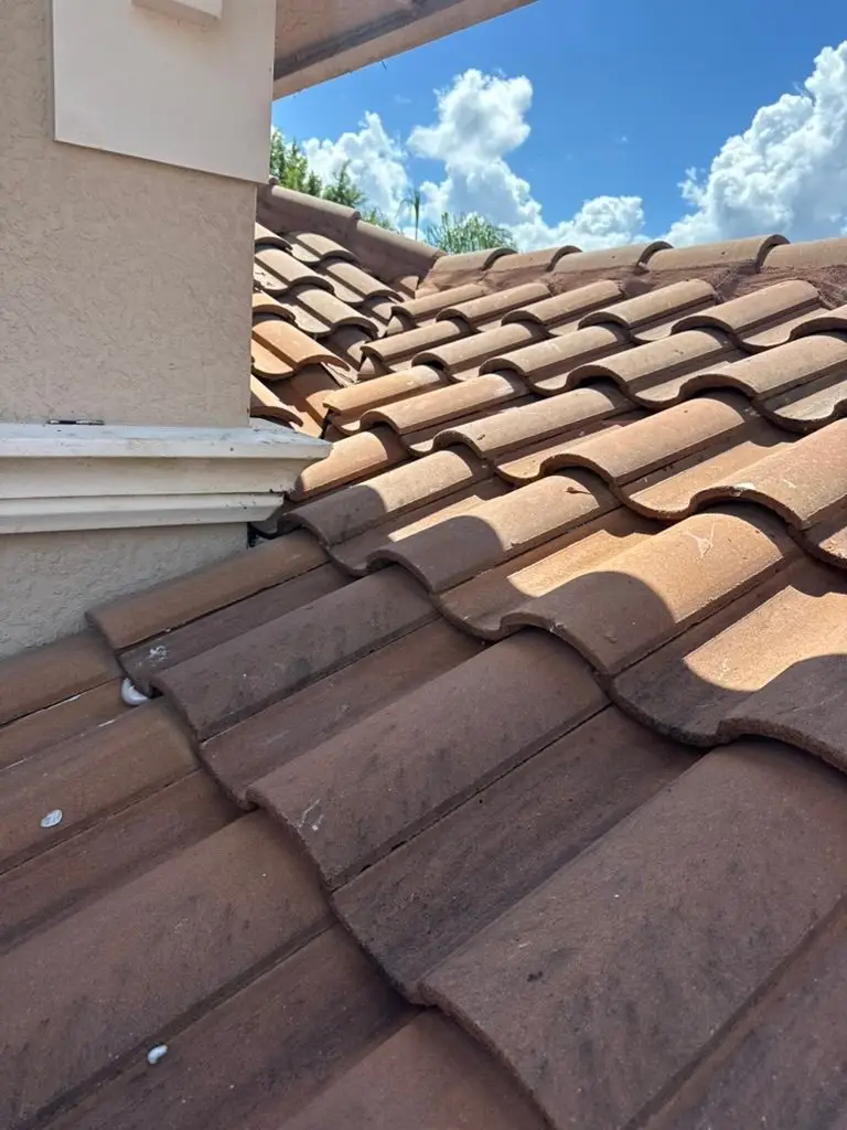 Roof tiles reinstalled with foam adhesive after flashing wall leak repair in Riverstone, Naples